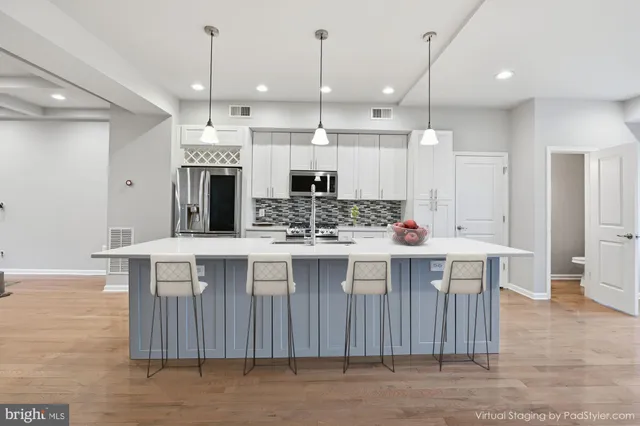 a kitchen with stainless steel appliances granite countertop a sink a stove a refrigerator and white cabinets