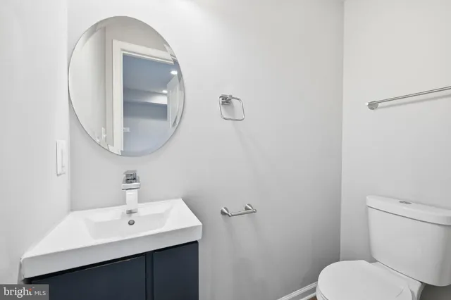 a bathroom with a toilet a sink and mirror