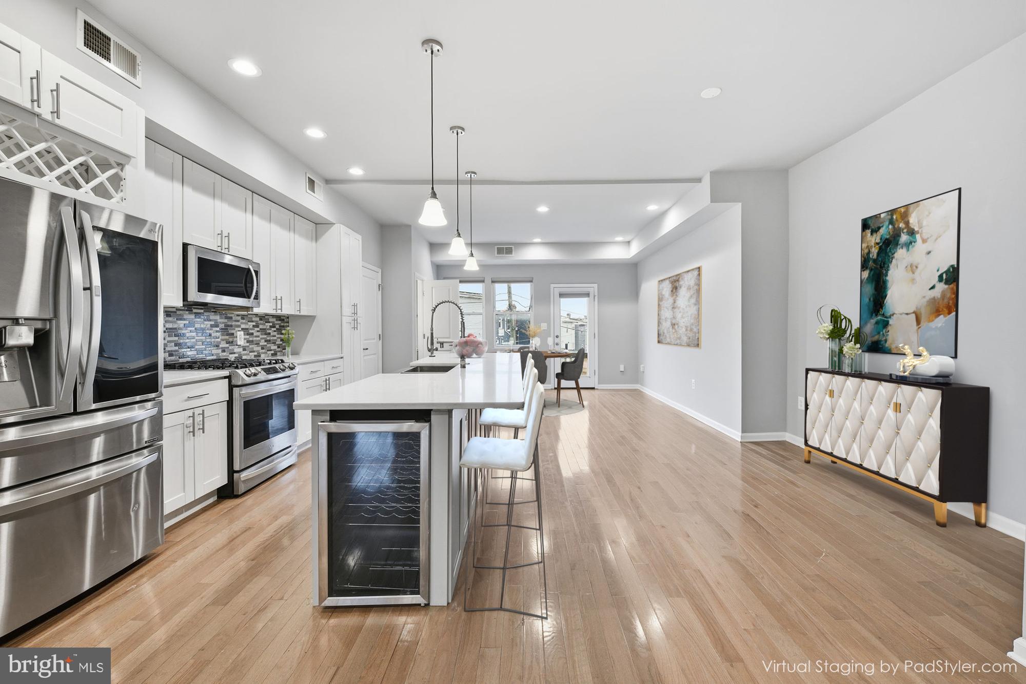 824 Allison Street Northwest Washington, DC 20011 - Photo 3 of 26 a kitchen with stainless steel appliances kitchen island granite countertop a stove top oven a sink dishwasher a dining table and chairs with wooden floor