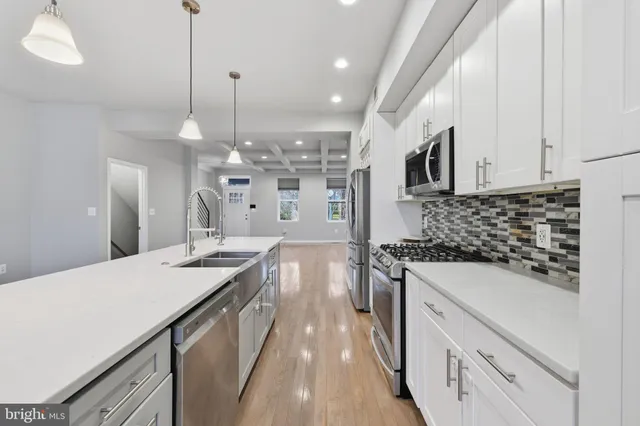 a kitchen with a sink stove and white cabinets