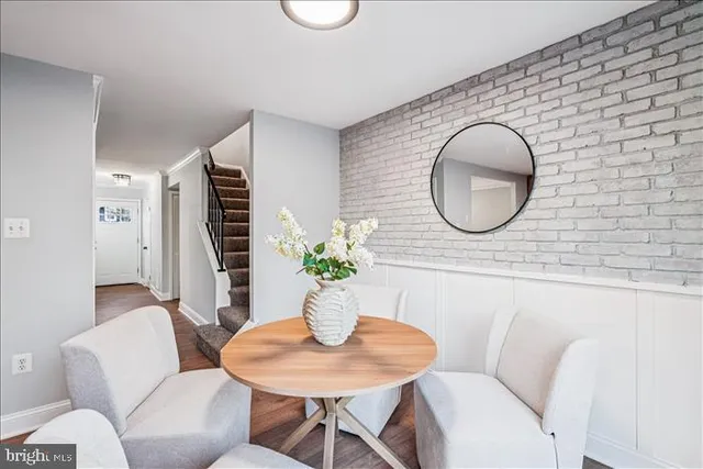 a living room with furniture a potted plant and a large window