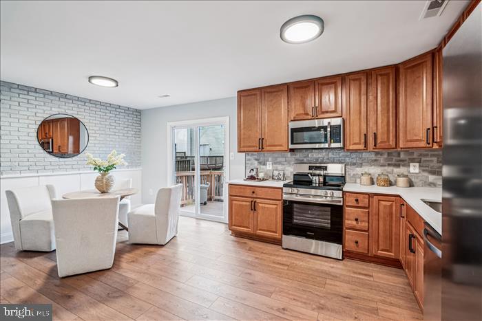 7646 South Arbory Lane, Unit 320 Laurel, MD 20707 - Photo 16 of 45 a kitchen with stainless steel appliances granite countertop a stove top oven a sink dishwasher and white cabinets with wooden floor