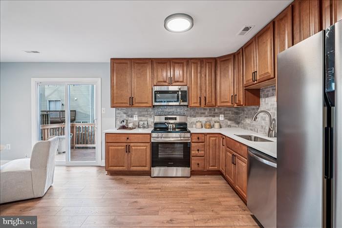 7646 South Arbory Lane, Unit 320 Laurel, MD 20707 - Photo 17 of 45 a kitchen with stainless steel appliances granite countertop a stove top oven a refrigerator and a view of living room