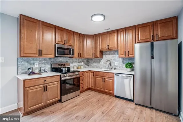 a kitchen with granite countertop wooden floors stainless steel appliances and cabinets