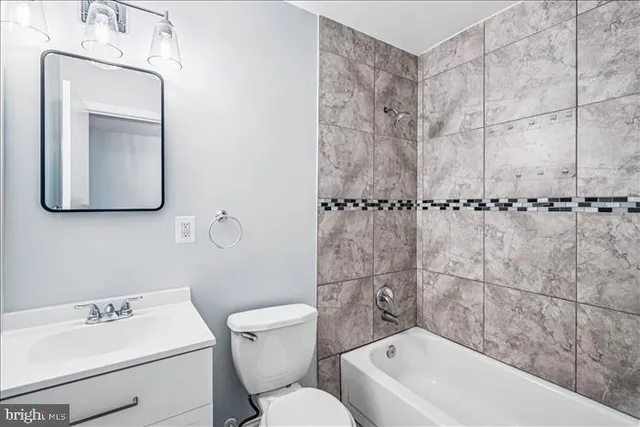 a bathroom with a toilet a sink a mirror and bathtub