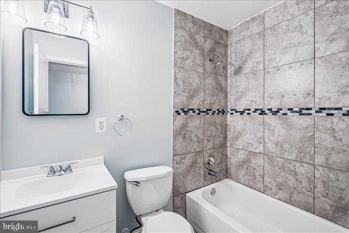 7646 South Arbory Lane, Unit 320 Laurel, MD 20707 - Photo 21 of 45 a bathroom with a toilet a sink a mirror and bathtub
