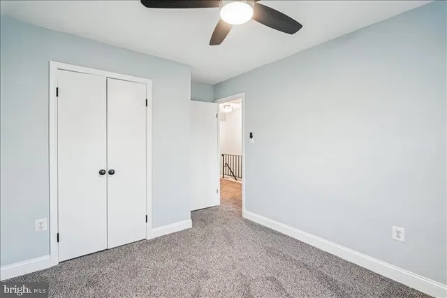 an empty room with a window and ceiling fan