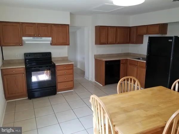 a kitchen with granite countertop a stove top oven and cabinets