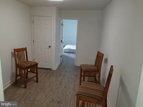 a view of a hallway with furniture and wooden floor