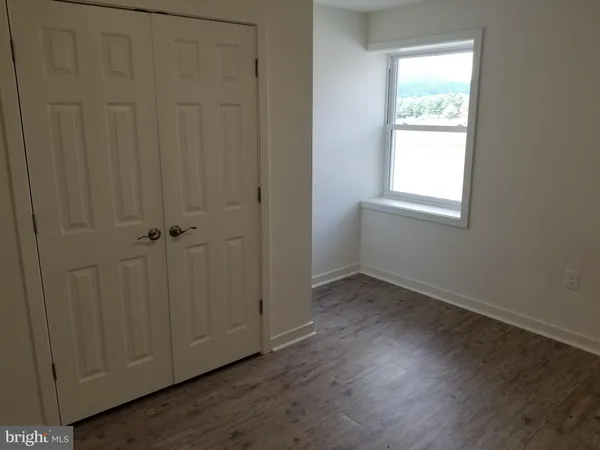 an empty room with wooden floor and a window