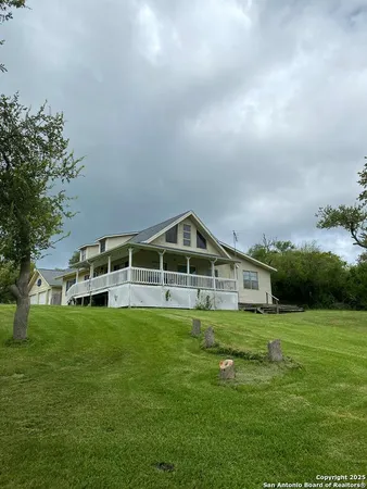 a view of a house with a big yard and large trees