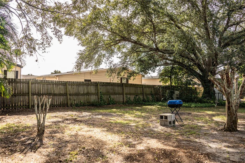 3304 Fox Ridge Drive Winter Haven, FL 33884 - Photo 48 of 60 a view of a yard with a bench and wooden fence