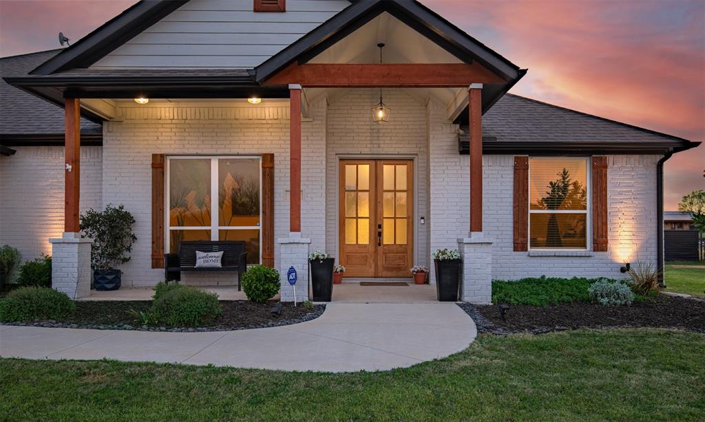 111 Bluegrass Trail Springtown, TX 76082 - Photo 6 of 37 Fresh mulch, landscaping, and cozy front porch with double entry door warmly welcomes you inside.