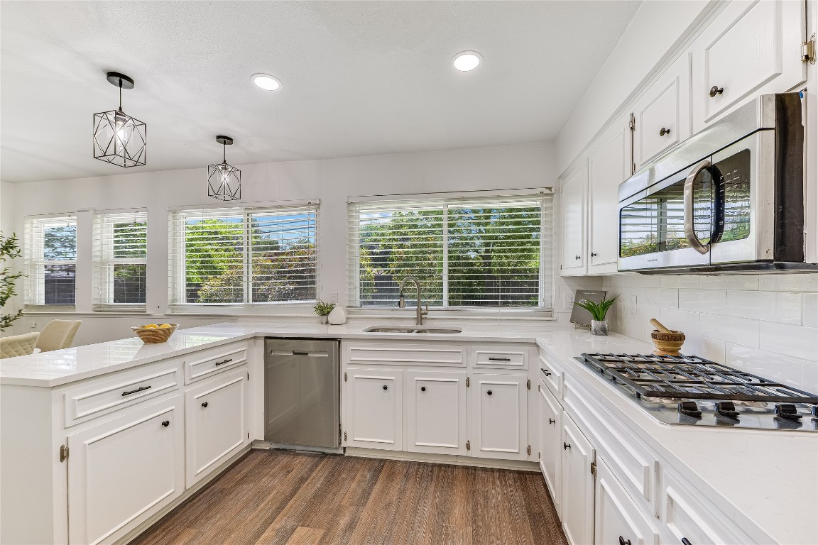 a white kitchen with a sink and cabinets