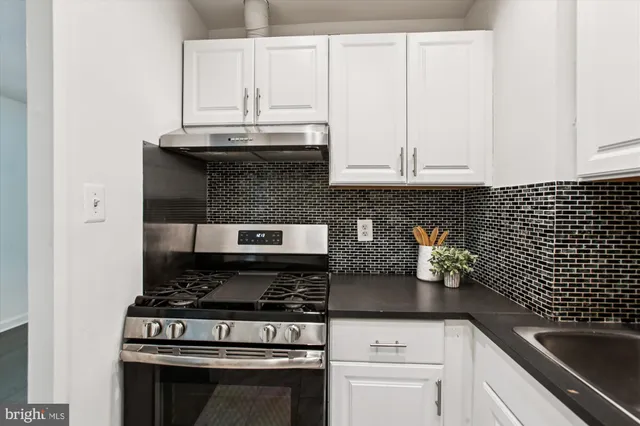 a kitchen with granite countertop a stove top oven