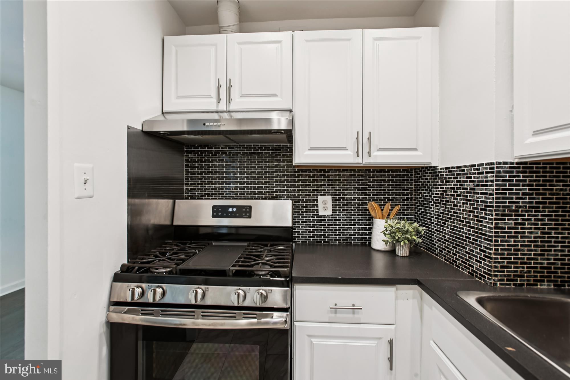 301 I Street Southwest, Unit 108 Washington, DC 20024 - Photo 11 of 55 a kitchen with granite countertop a stove top oven