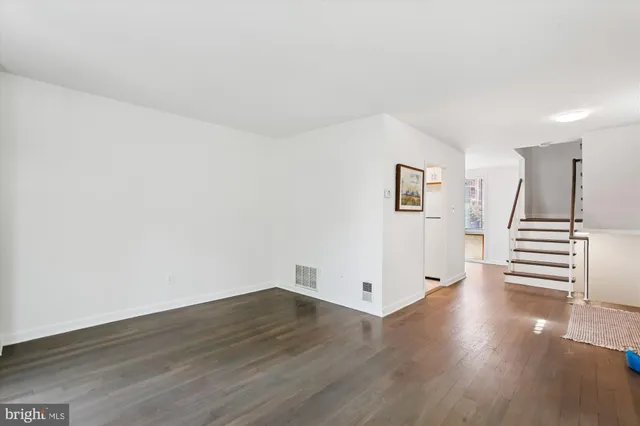 a view of a livingroom with wooden floor and white walls