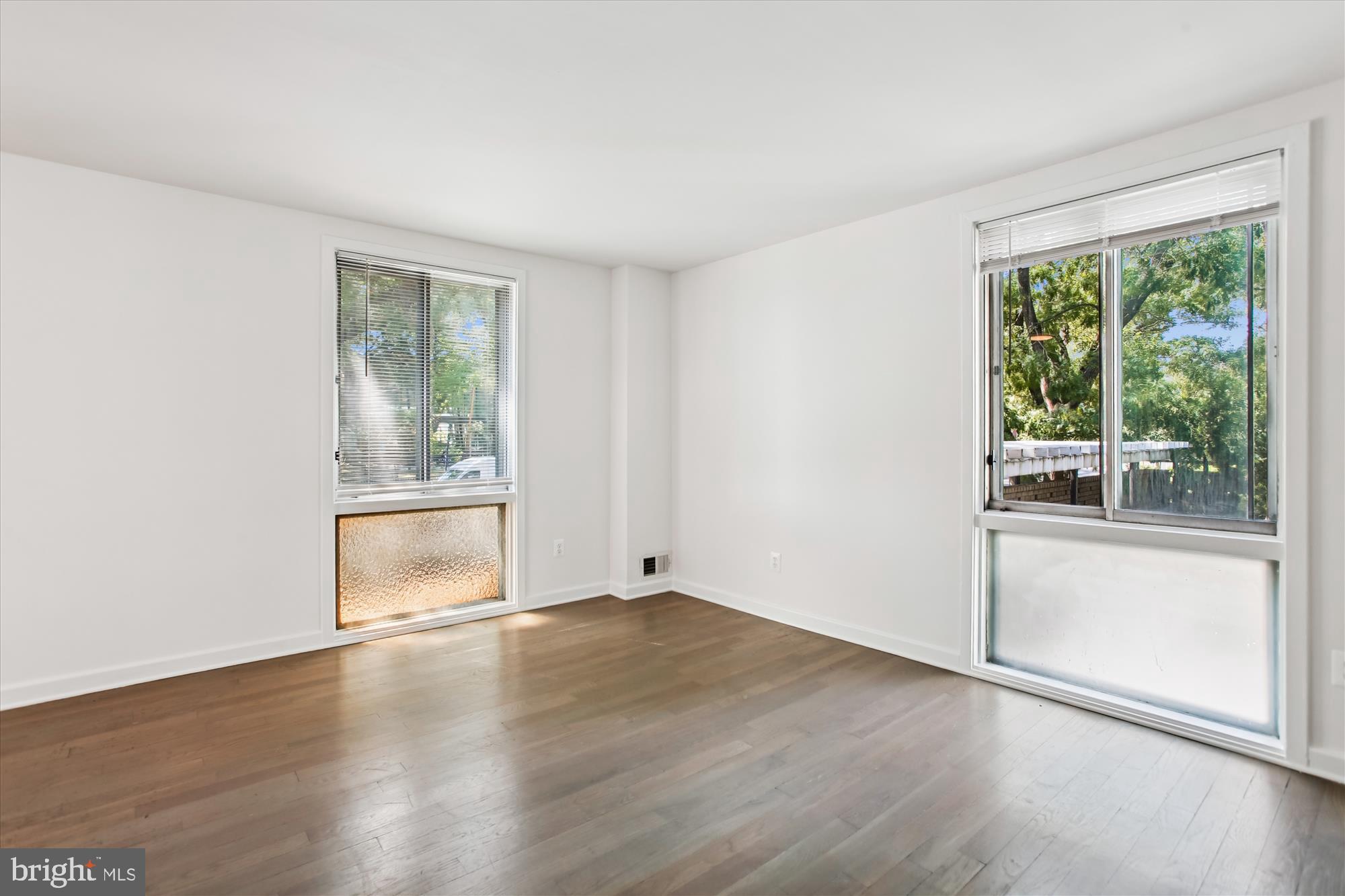 301 I Street Southwest, Unit 108 Washington, DC 20024 - Photo 14 of 55 an empty room with wooden floor and windows