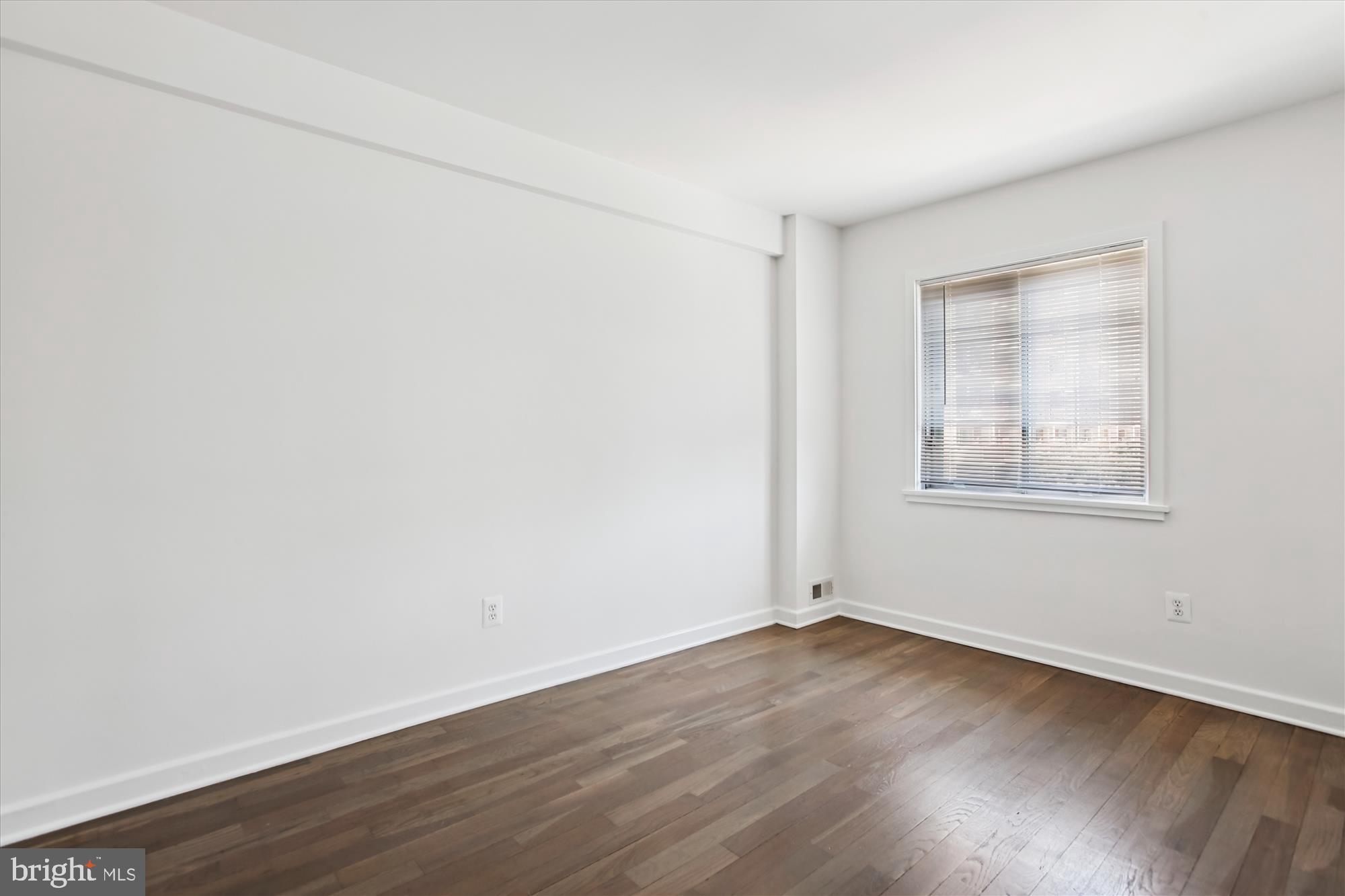 301 I Street Southwest, Unit 108 Washington, DC 20024 - Photo 23 of 55 an empty room with wooden floor and windows