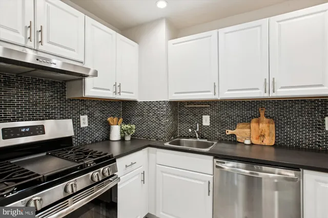 a kitchen with stainless steel appliances granite countertop a sink stove and cabinets