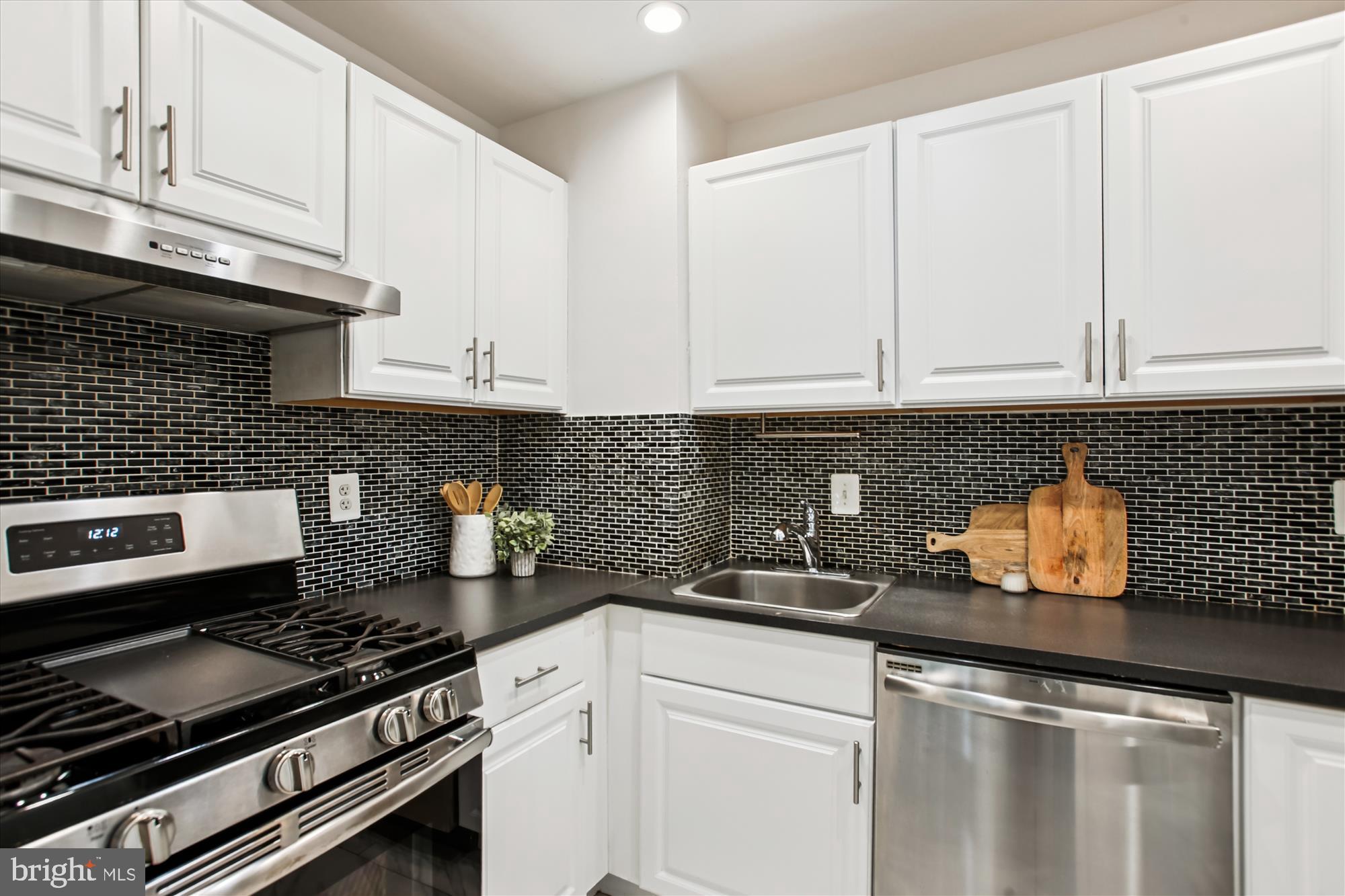 301 I Street Southwest, Unit 108 Washington, DC 20024 - Photo 8 of 55 a kitchen with stainless steel appliances granite countertop a sink stove and cabinets