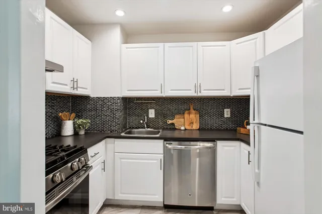 a kitchen with granite countertop white cabinets and white appliances