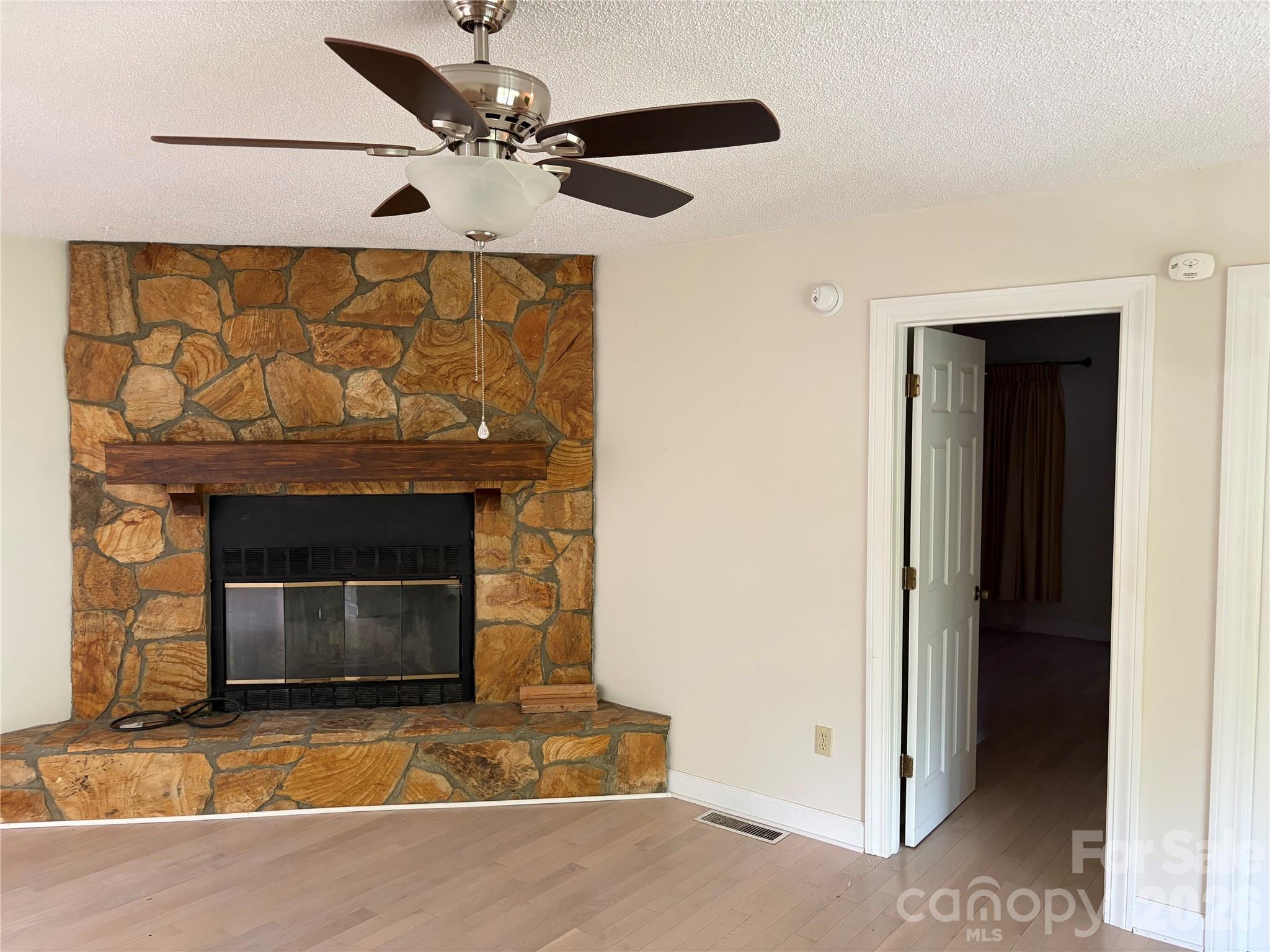 256 A Bruce Road Mars Hill, NC 28754 - Photo 32 of 39 a living room with a fireplace and a ceiling fan