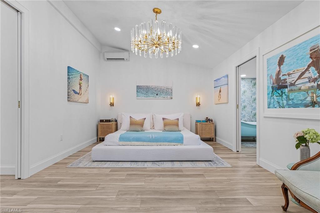 725 2nd Street South Naples, FL 34102 - Photo 9 of 21 a bedroom with a large bed and a chandelier