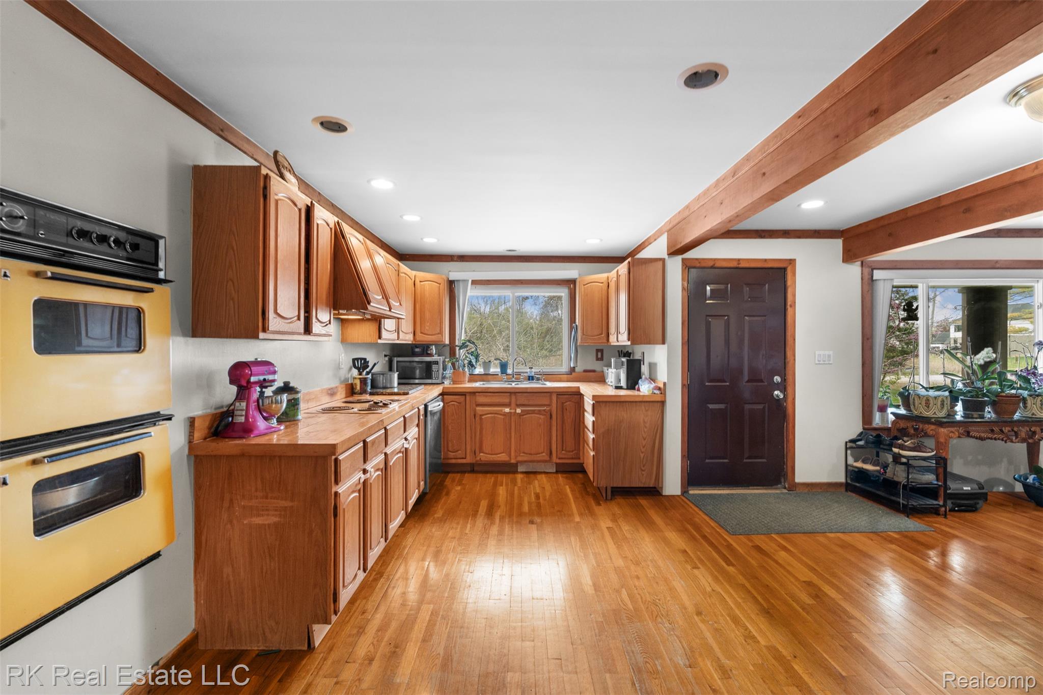 13799 31 Mile Road Washington, MI 48095 - Photo 11 of 40 Kitchen with light countertops, light wood-style flooring, beam ceiling, recessed lighting, and wood finish cabinets