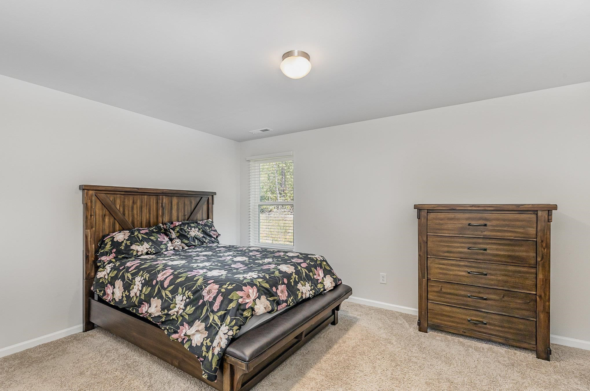 226 Hallow Oak Street Spring Lake, NC 28390 - Photo 19 of 30 a bed sitting in a bedroom next to a window and dresser