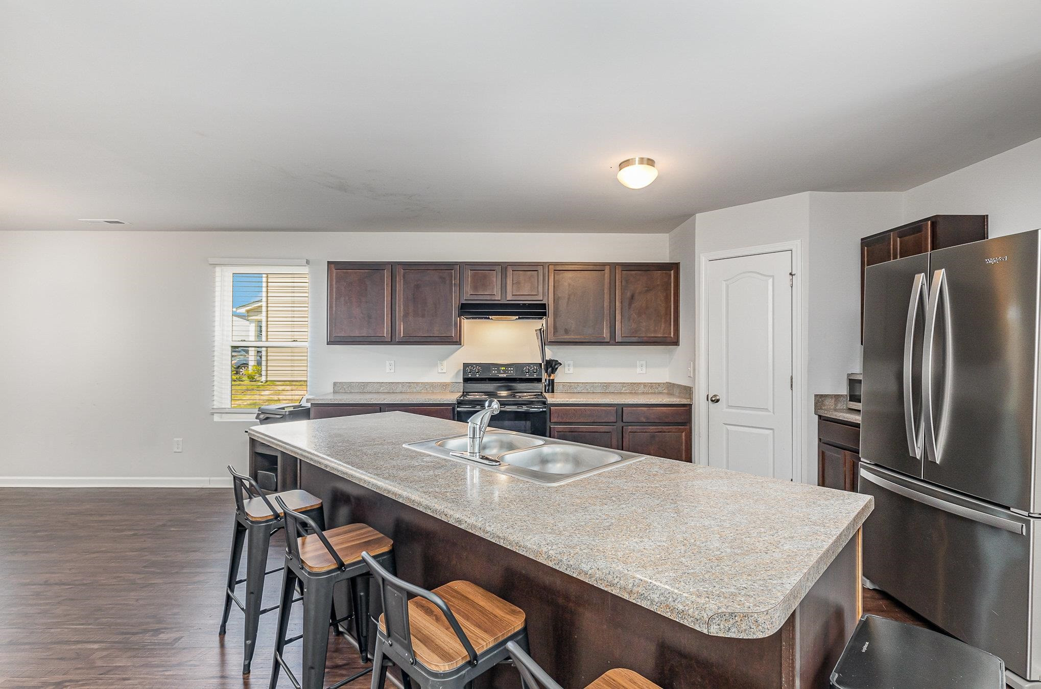 226 Hallow Oak Street Spring Lake, NC 28390 - Photo 10 of 30 a kitchen with stainless steel appliances granite countertop a table chairs and refrigerator