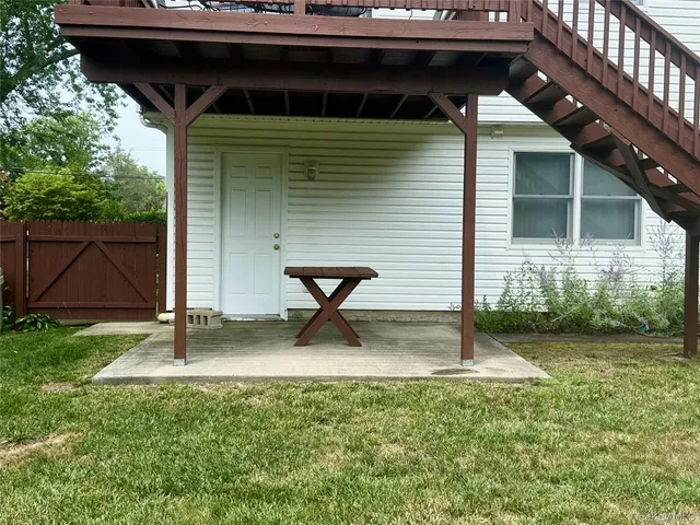 a view of backyard with a tub and wooden fence