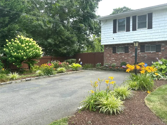 a front view of a house with a yard and a garden