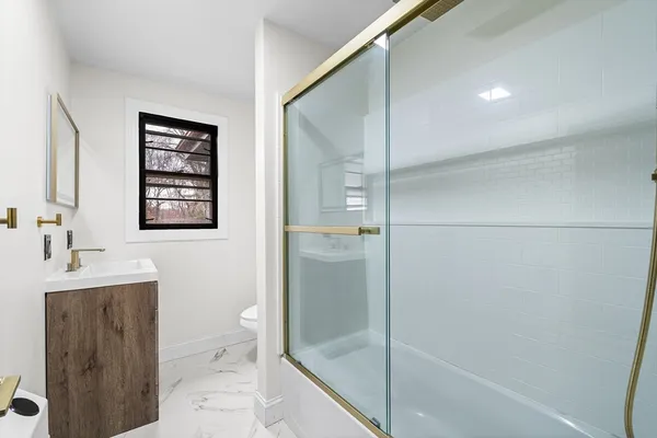 a bathroom with a shower sink and toilet