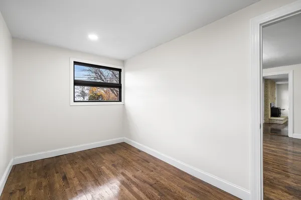 a view of empty room with wooden floor