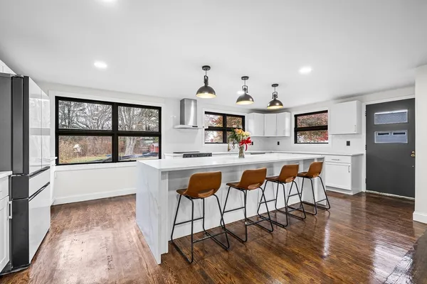 a dining hall with stainless steel appliances kitchen island granite countertop a dining table chairs and view of living room