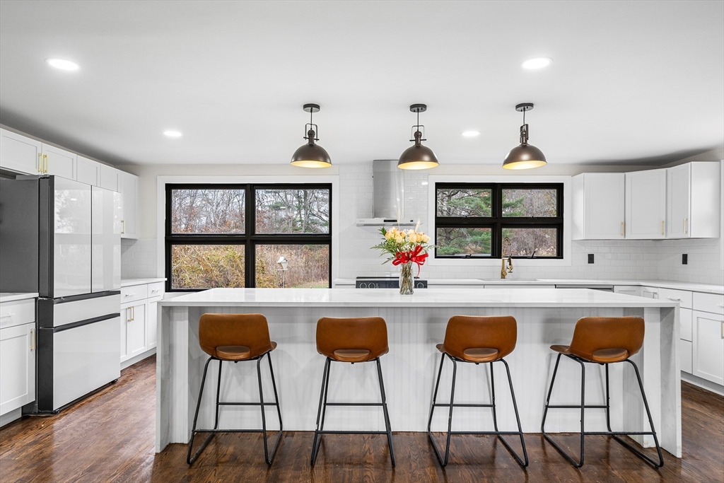 195 Barney Avenue Rehoboth, MA 02769 - Photo 6 of 37 a kitchen with white cabinets and chairs