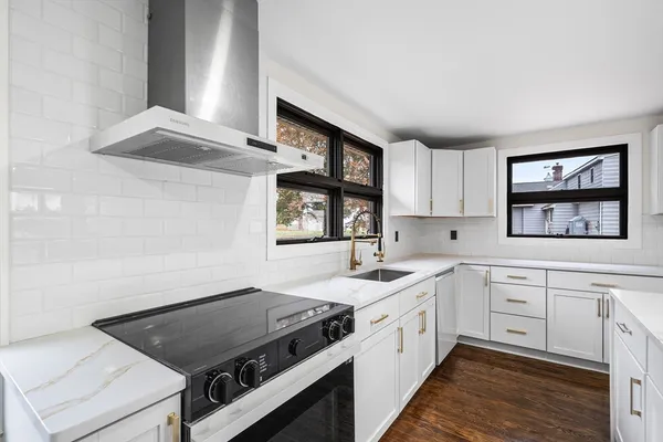 a kitchen with a stove cabinets and a window