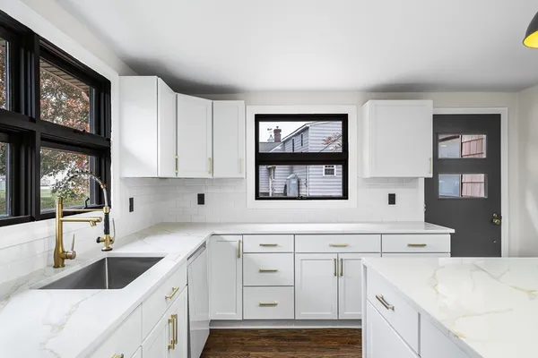 a kitchen with stainless steel appliances granite countertop a sink and a stove with cabinets