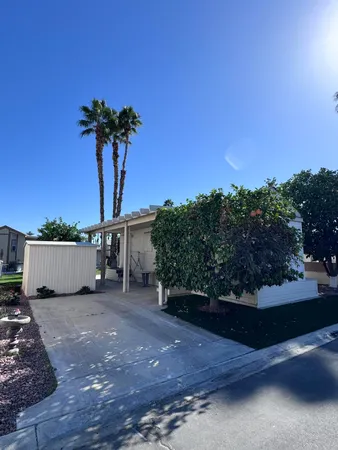 a view of a house with a yard and potted plants
