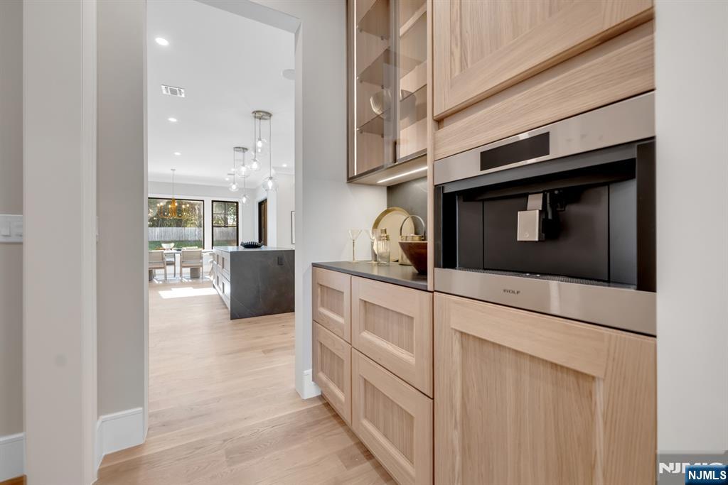 12 Echo Ridge Road Upper Saddle River, NJ 07458 - Photo 19 of 49 a kitchen with stainless steel appliances white cabinets and wooden floors