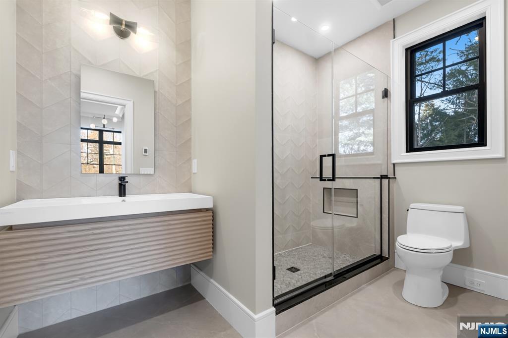 12 Echo Ridge Road Upper Saddle River, NJ 07458 - Photo 37 of 49 a bathroom with a toilet sink a mirror and shower