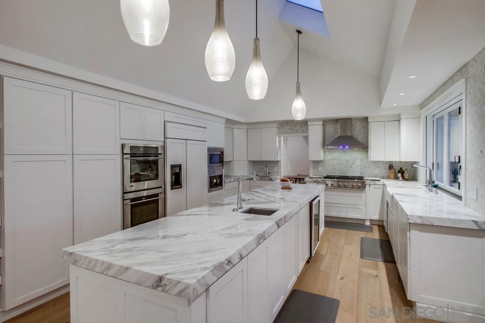 4124 Stonebridge Lane Rancho Santa Fe, CA 92091 - Photo 11 of 38 a large kitchen with kitchen island a stove a sink a refrigerator and a wooden floors