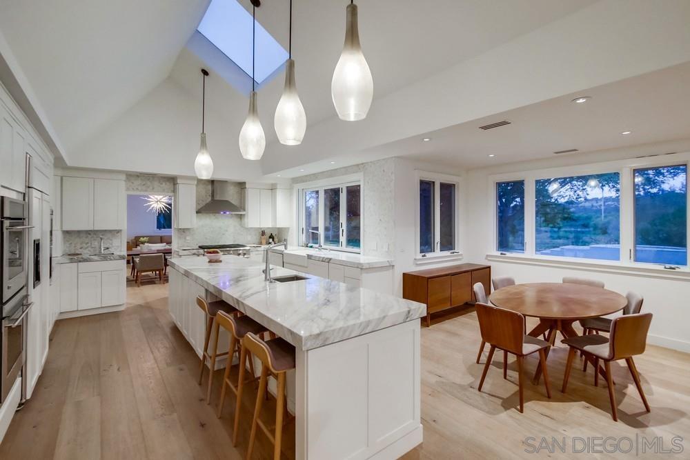 4124 Stonebridge Lane Rancho Santa Fe, CA 92091 - Photo 13 of 38 a kitchen with a table chairs stove and wooden floor