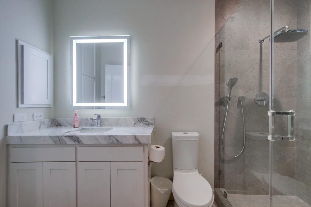 4124 Stonebridge Lane Rancho Santa Fe, CA 92091 - Photo 25 of 38 a bathroom with a toilet sink vanity and shower