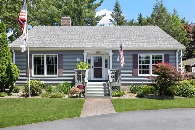 a front view of a house with a yard and potted plants