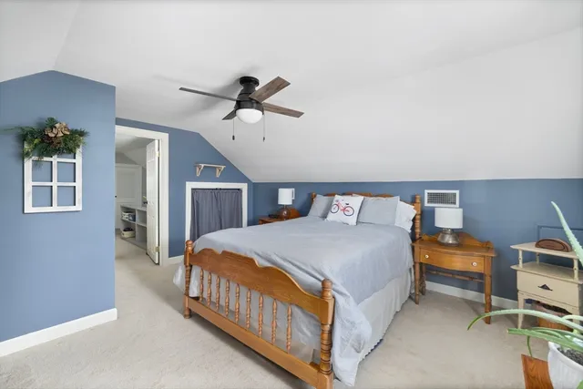 a bedroom with a bed a dresser and book shelfs
