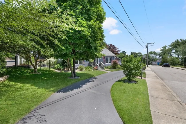 a front view of a house with a yard and trees