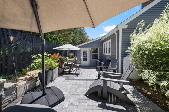 a view of a patio with chairs and potted plants