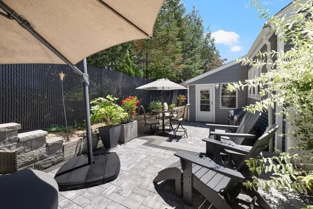a view of a patio with couches table and chairs under an umbrella